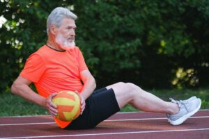 Man exercising with a medicine ball outdoors.