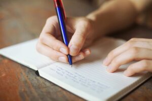 Handwriting notes in an open notebook.